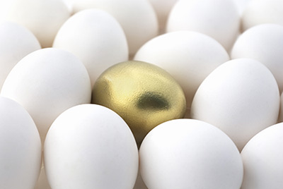 Golden egg in between white eggs